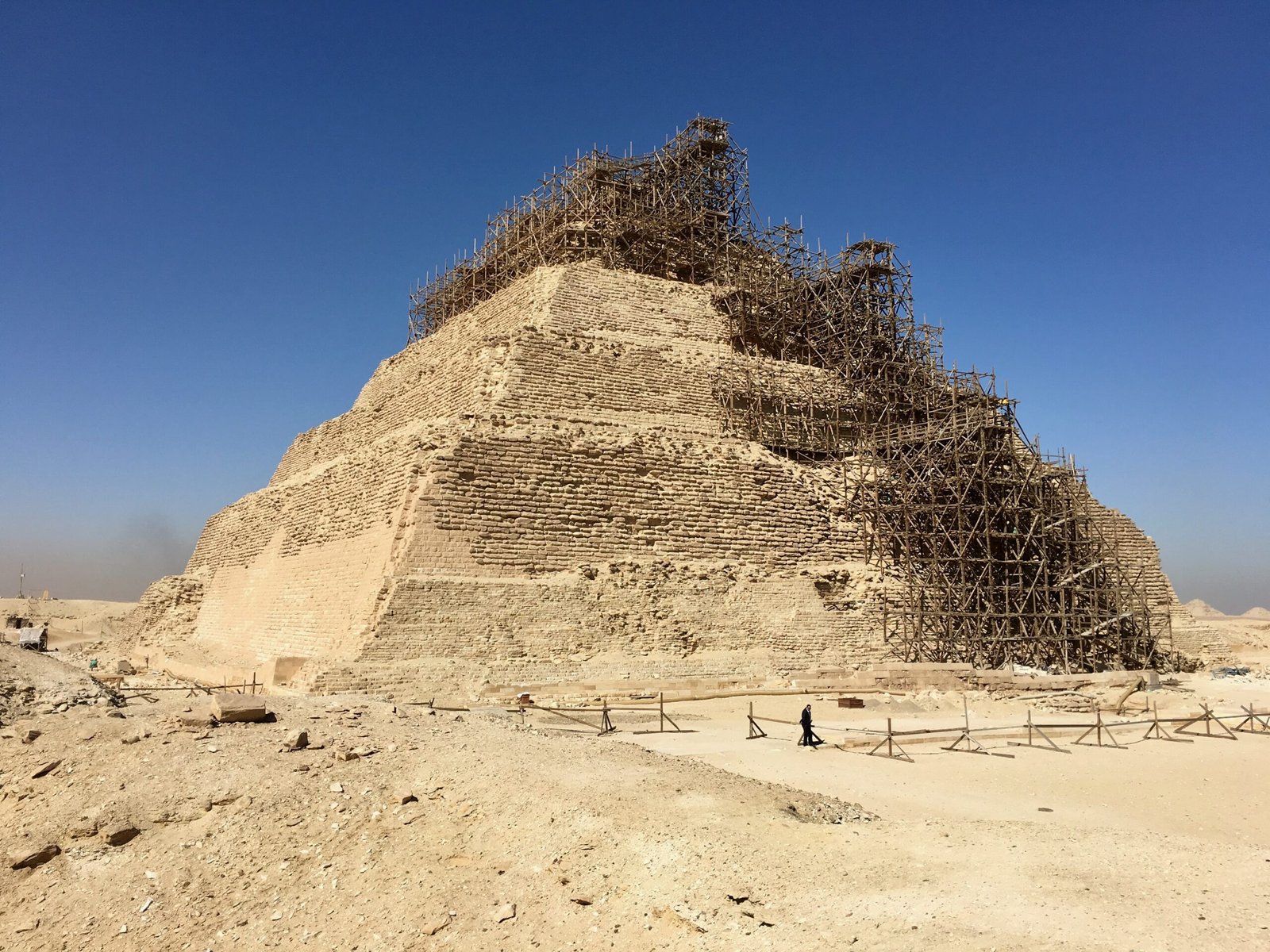 Pyramid of Djoser with scaffolding partially covering its structure for preservation efforts.