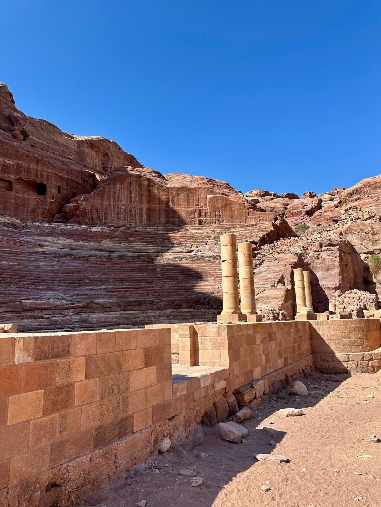 The semi-circular Nabatean Theatre at Petra, with seats carved into the sandstone canyon walls.