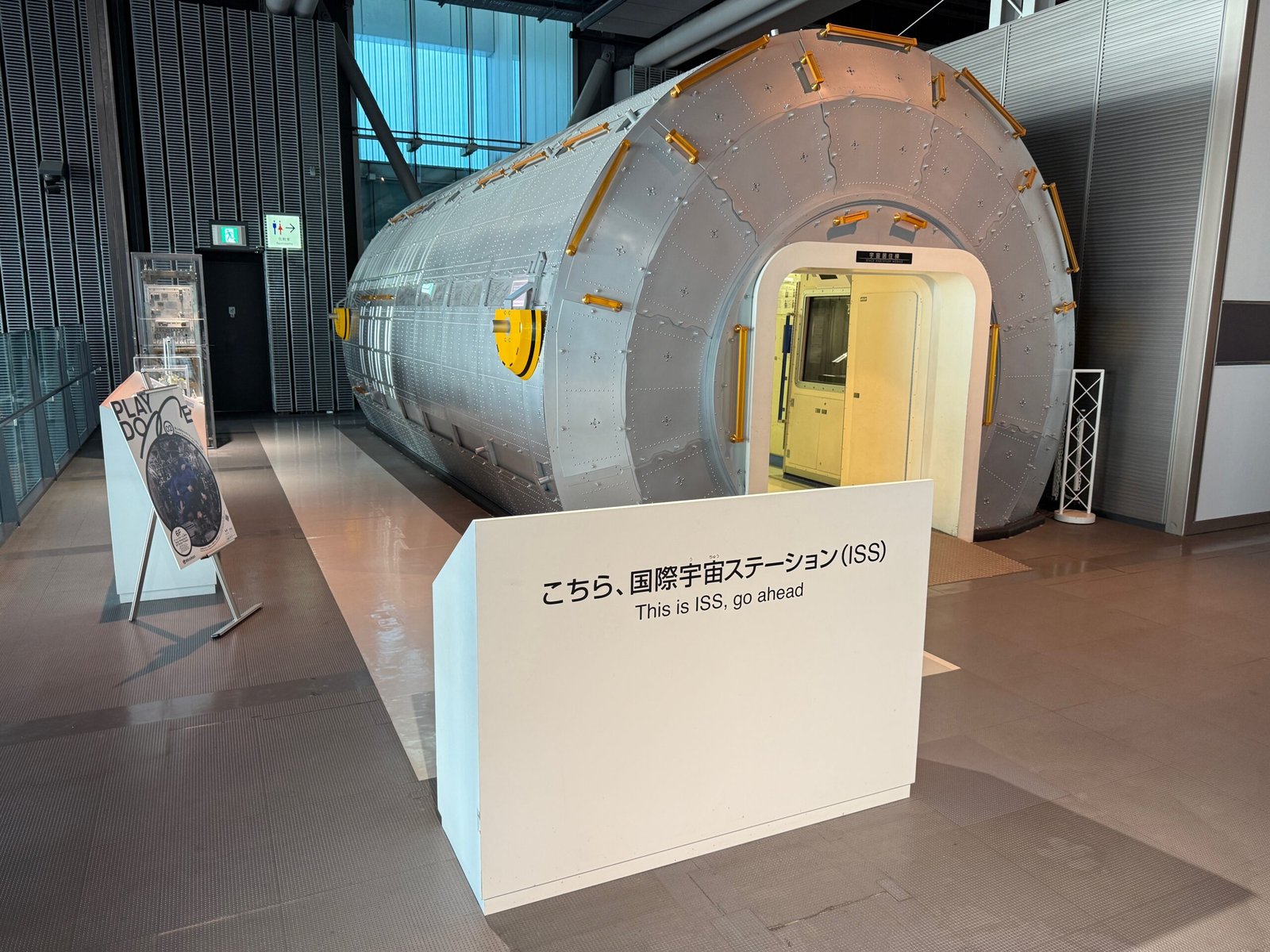 A cylindrical ISS Replica Module display at Miraikan, shown from the outside.