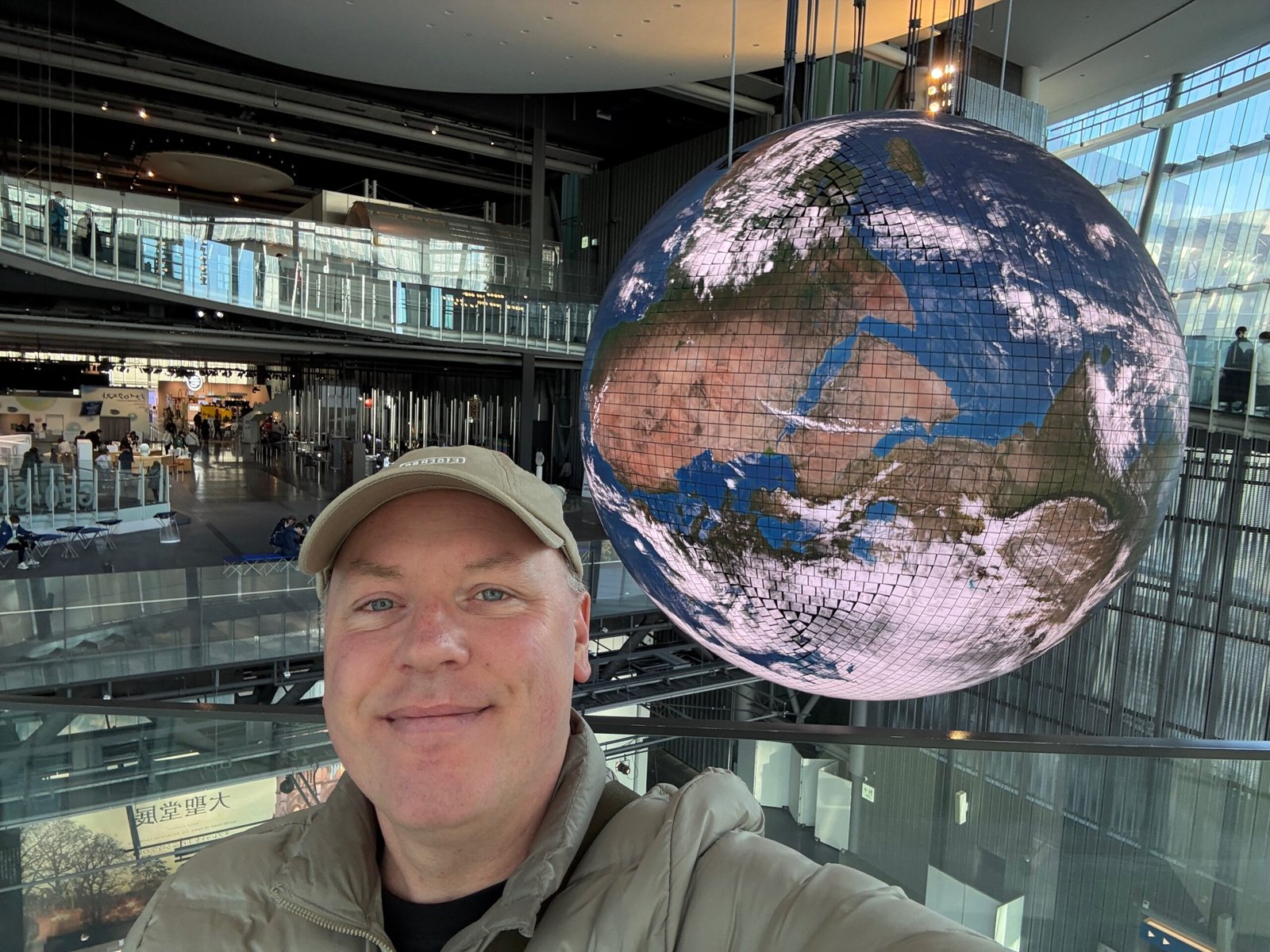 Don Trynor, author at Curious Don, standing in front of the illuminated Geo-Cosmos globe at the National Museum of Emerging Science and Innovation in Tokyo.