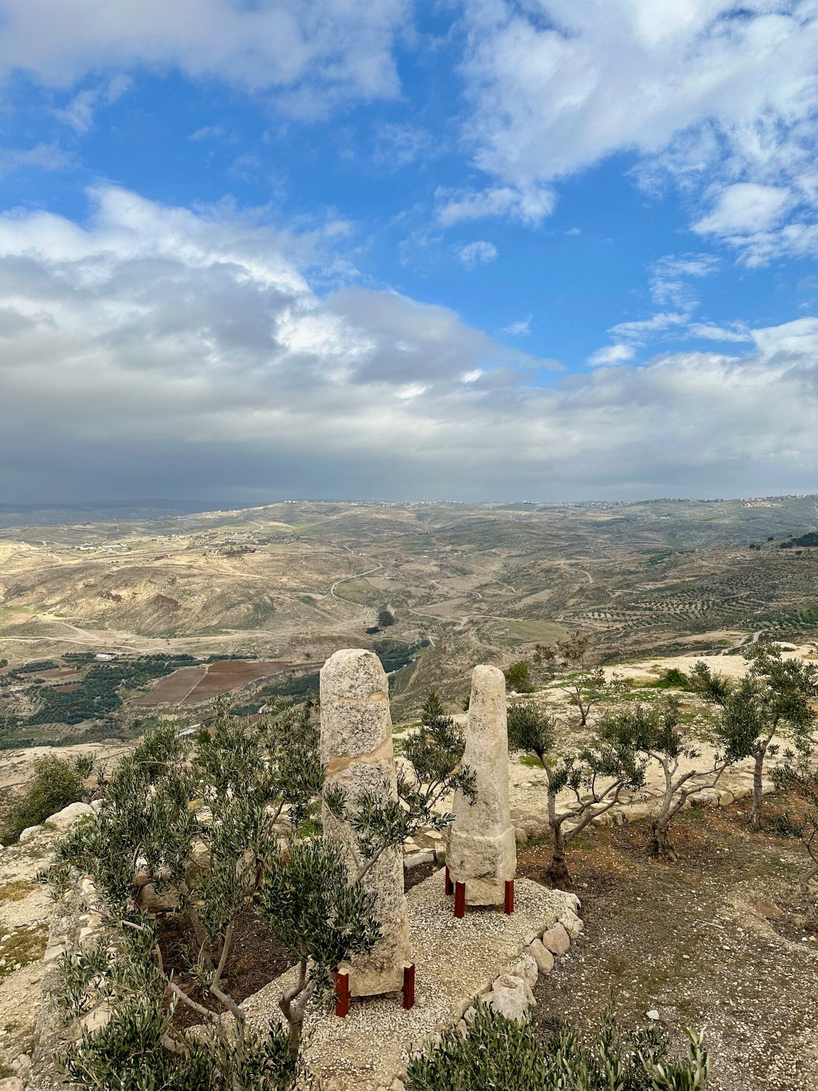 Panoramic view from Mount Nebo in Jordan, overlooking the Dead Sea and the distant horizon under a clear sky.